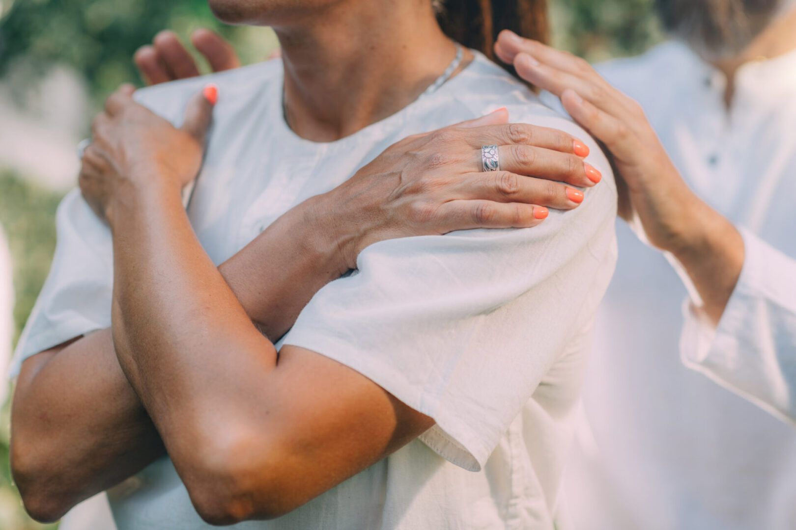A person with orange nail polish wearing a Simple Placeholder Product 1 shirt holds their shoulders, as another's hands rest on theirs from behind. Both wear Simple Placeholder Product 1 shirts.