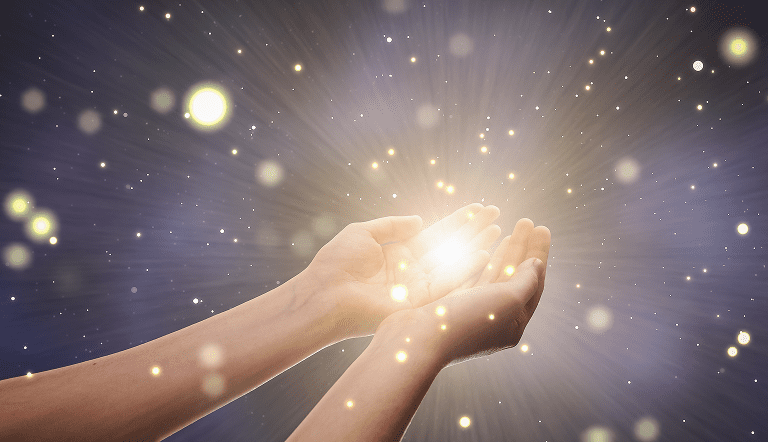 3 Hands cupped together, holding a glowing light against a starry background.